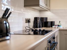 A kitchen countertop with a kettle and cooking hob at Bay Bungalow
