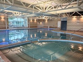 An indoor pool with a ladder and windows at Bay Bungalow near Carnforth