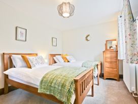 A bedroom with two beds and a dresser at Hillberry Cottage in Carnforth