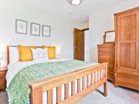 A bedroom with a bed and dresser at Hillberry Cottage in Carnforth
