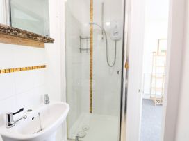 A bathroom with a sink and shower at The Mill House Apartment