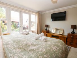A bedroom with a bed and television at The Mill House Apartment