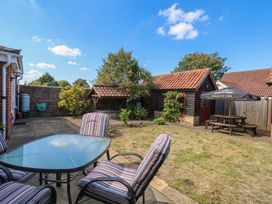 A garden with a patio table and chairs at The Mill House Apartment