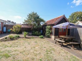 A garden with a shed and seating area at The Mill House Apartment 