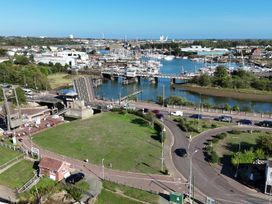 An outdoor view of a marina with boats and a bridge at The Mill House Apartment Oulton Broad