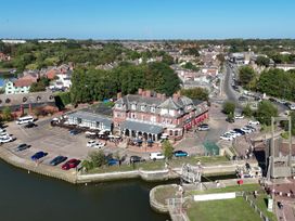 A building near a parking lot and river at The Mill House Apartment in Oulton Broad