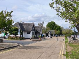 A view of thatched roof buildings along a pathway at The Mill House Apartment Oulton Broad