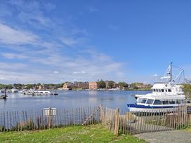 A view of boats in water with buildings in the background at The Mill House Apartment Oulton Broad