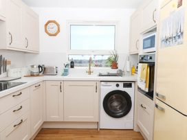 A kitchen with a washing machine and refrigerator at Elberry Cove View in Paignton