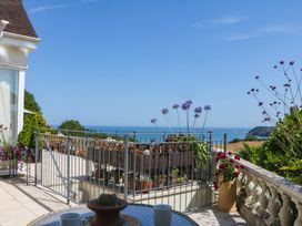 A patio with railing and planters overlooking the sea at Elberry Cove View in Paignton