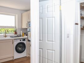 A laundry room with a washing machine and kitchen sink at Elberry Cove View Paignton