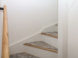 A staircase with wooden handrail at Elberry Cove View in Paignton