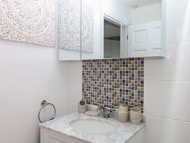A bathroom with a sink and decorative tiles at Elberry Cove View in Paignton