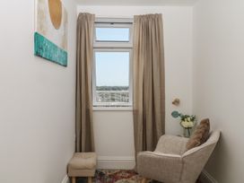 A small room with a chair and a window at Elberry Cove View in Paignton