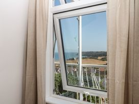 A window showing a view of the sea and landscape at Elberry Cove View in Paignton