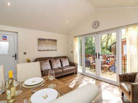A dining room with a sofa and table at Fir Tree Lodge, Coniston 3, White Cross Bay near Windermere