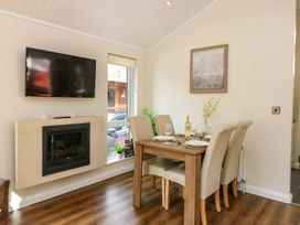 A dining room with a table set for dinner at Fir Tree Lodge Coniston 3, White Cross Bay near Windermere