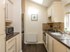 A kitchen with microwave and stove at Fir Tree Lodge in Coniston 3, White Cross Bay near Windermere