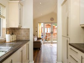 A kitchen with a view of the living area at Fir Tree Lodge, Coniston 3, White Cross Bay near Windermere