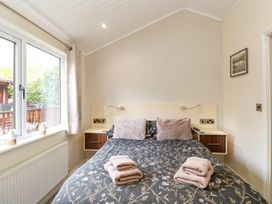 A bedroom with a bed and pillows at Fir Tree Lodge in Coniston 3, White Cross Bay near Windermere