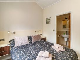 A bedroom with a bed and an ensuite bathroom at Fir Tree Lodge near Coniston 3, White Cross Bay near Windermere