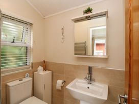 A bathroom with a sink, toilet, and mirror at Fir Tree Lodge, Coniston 3, White Cross Bay near Windermere