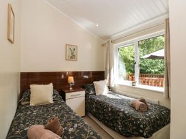 A bedroom with two beds and a window at Fir Tree Lodge, Coniston 3, White Cross Bay near Windermere