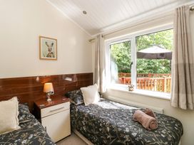 A bedroom with two single beds and a window at Fir Tree Lodge, Coniston 3, White Cross Bay near Windermere
