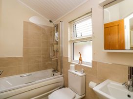 A bathroom with a bathtub and shower at Fir Tree Lodge Coniston 3 White Cross Bay near Windermere
