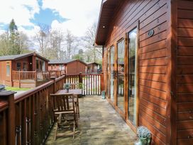 An outdoor area with a wooden decking and chairs at Fir Tree Lodge in Coniston 3, White Cross Bay near Windermere