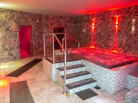 An indoor spa area with a whirlpool and stairs at Fir Tree Lodge, Coniston 3, White Cross Bay near Windermere