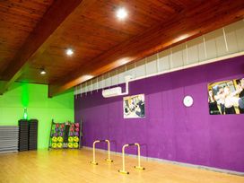 A gym with exercise equipment and wooden beams at Fir Tree Lodge, Coniston 3, White Cross Bay near Windermere
