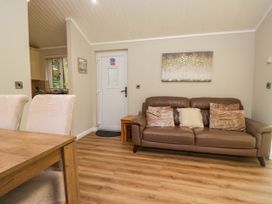A living room with a sofa and dining table at Fir Tree Lodge, White Cross bay on Windermere, Troutbeck Bridge