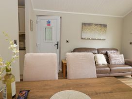 A living room with a sofa and table at Fir Tree Lodge White Cross bay on Windermere, Troutbeck Bridge
