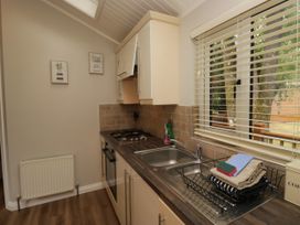 A kitchen with sink and stove at Fir Tree Lodge in White Cross bay on Windermere, Troutbeck Bridge