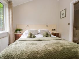 A bedroom with a bed and a bedside table at Fir Tree Lodge in White Cross bay on Windermere, Troutbeck Bridge