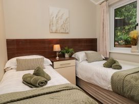 A bedroom with two beds and a window at Fir Tree Lodge, White Cross bay on Windermere, Troutbeck Bridge
