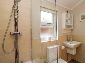 A bathroom featuring a shower, toilet, sink and window at Fir Tree Lodge, White Cross bay on Windermere, Troutbeck Bridge