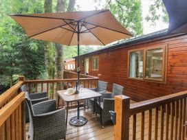 An outdoor seating area with a table and chairs at Fir Tree Lodge White Cross bay on Windermere Troutbeck Bridge