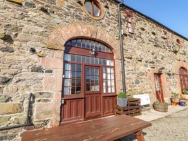 An outdoor area with a wooden door and stone wall at Mellfell Cottage near Watermillock