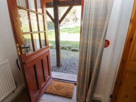 An entrance with an open door and welcome mat at Mellfell Cottage near Watermillock