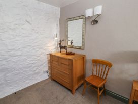 A bedroom with a dresser and mirror at Mellfell Cottage near Watermillock