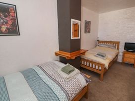 A bedroom with two beds and a television at Mellfell Cottage near Watermillock