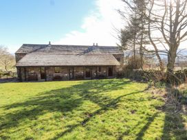 A building with a grassy area and trees at Mellfell Cottage near Watermillock