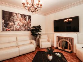 A living room with a sofa and television at Tudno Lodge Llandudno
