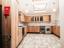 A kitchen with wooden cupboards and appliances at Tudno Lodge in Llandudno