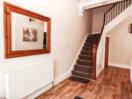 A hallway with a staircase and a mirror at Tudno Lodge Llandudno