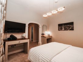A bedroom with bed, television, and desk at Tudno Lodge in Llandudno
