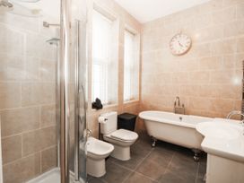 A bathroom with a bathtub, shower, toilet, and sink at Tudno Lodge in Llandudno