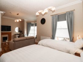 A bedroom with two beds and a sofa at Tudno Lodge in Llandudno